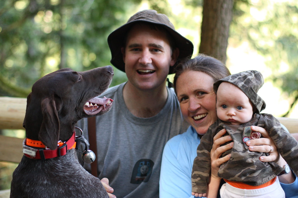 family with dog smiling at camera