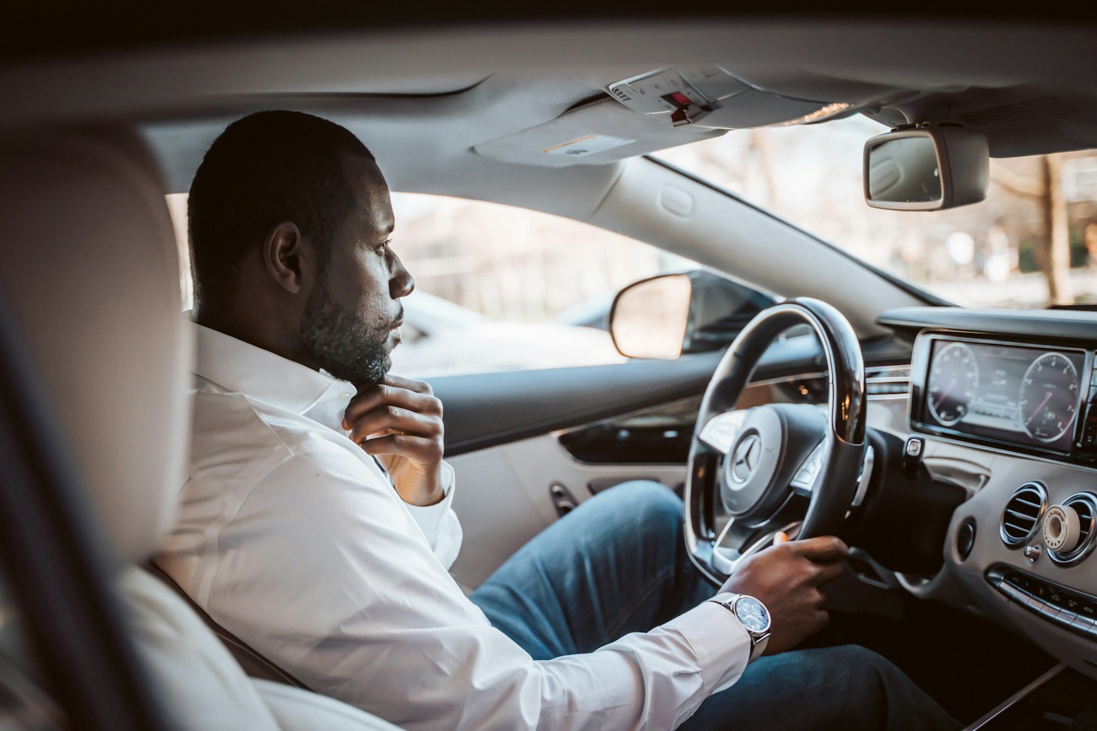 man in white dress shirt driving car during daytime, auto